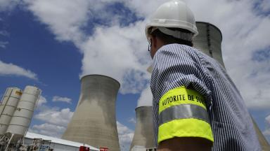 Photo d’une personne de l’Autorité de sûreté nucléaire devant une centrale nucléaire.